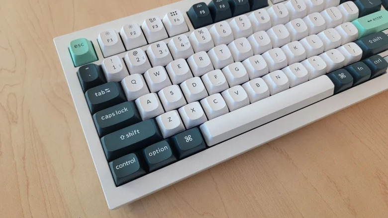 The left half of a Keychron Q1 HE keyboard on a bright wood desk.