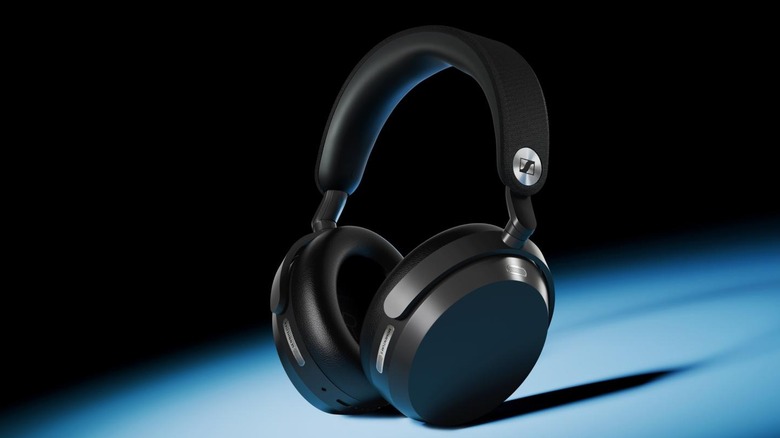 A pair of black Sennheiser Momentum 5 Wireless headphones sitting on a blue surface.