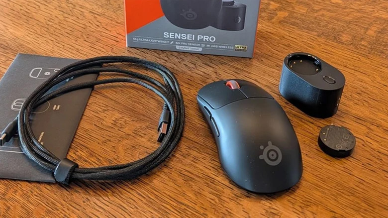 A Steelseries Pro X Rival mouse and its packaging contents on a desk.