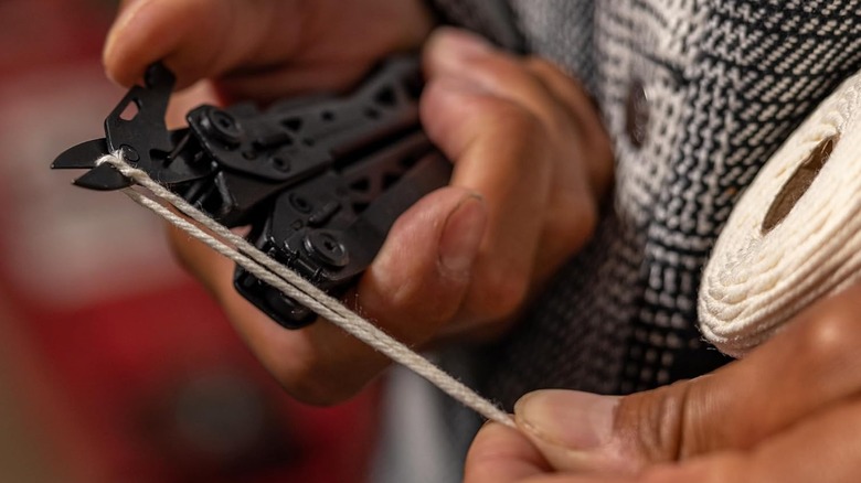 Gerber scissors being used to cut a piece of string