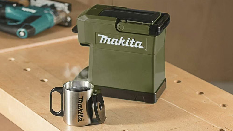 Makita coffee maker and travel mug with steaming coffee inside it