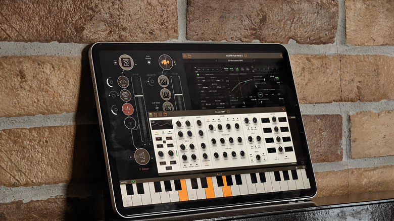 An iPad against a brick wall with the AUM app running on it