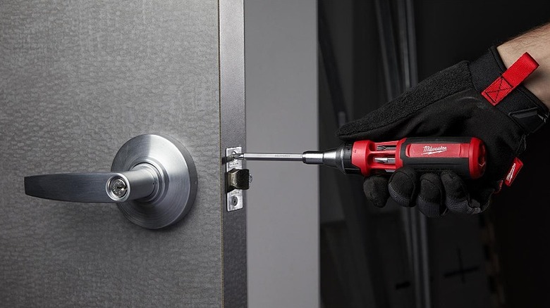 Using a multi-bit driver on a door's lock.