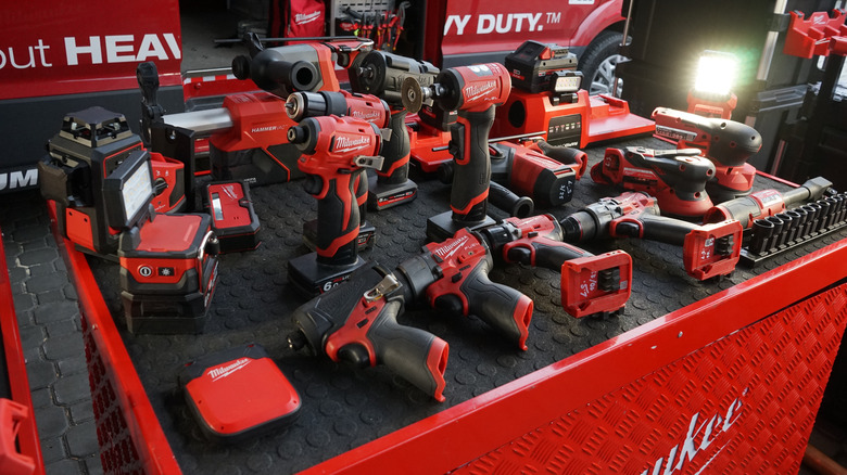 Several Milwaukee power tools and accessories placed on a Milwaukee table.