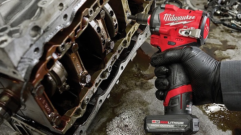 Using an impact wrench to work on automotive parts.