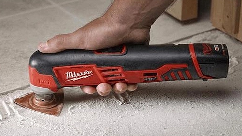 Using a multi-tool for scraping a surface.