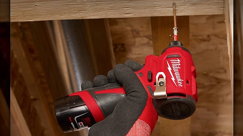 Using an impact driver for overhead fasteners.