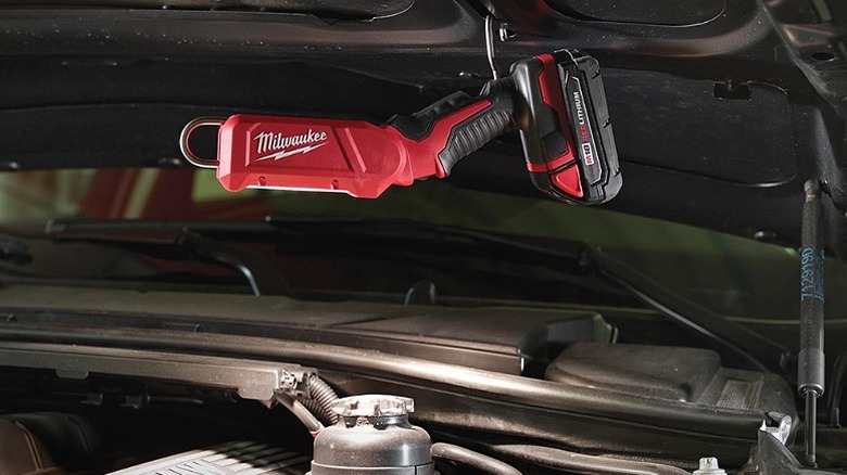 A stick light mounted under a car's engine hood.