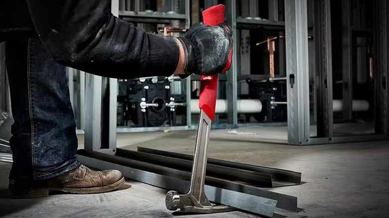 Using a hammer to lift metal bars.