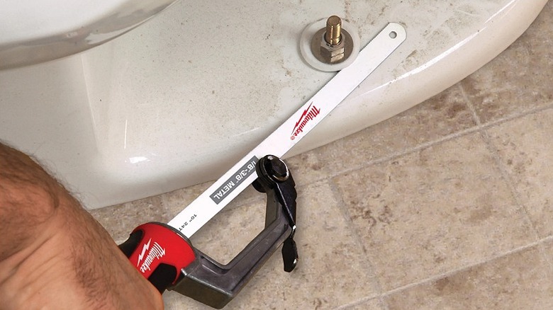 Using a hack saw on a bolt around a toilet.