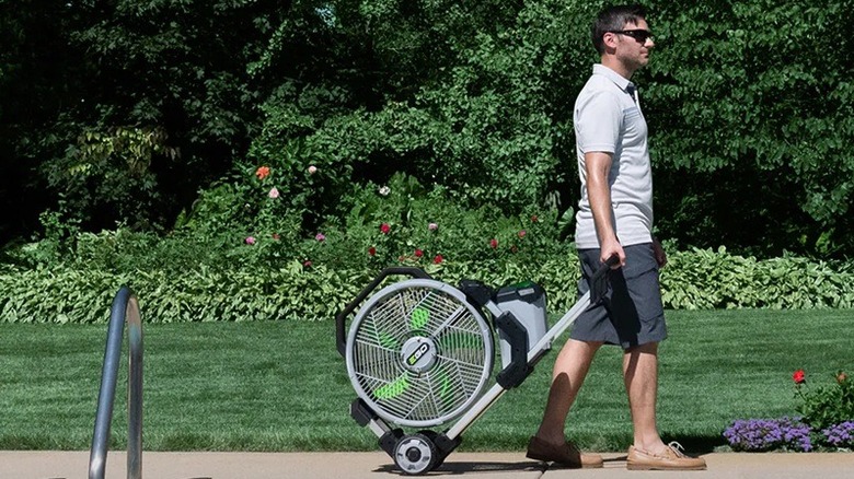 person pulling misting fan behind them