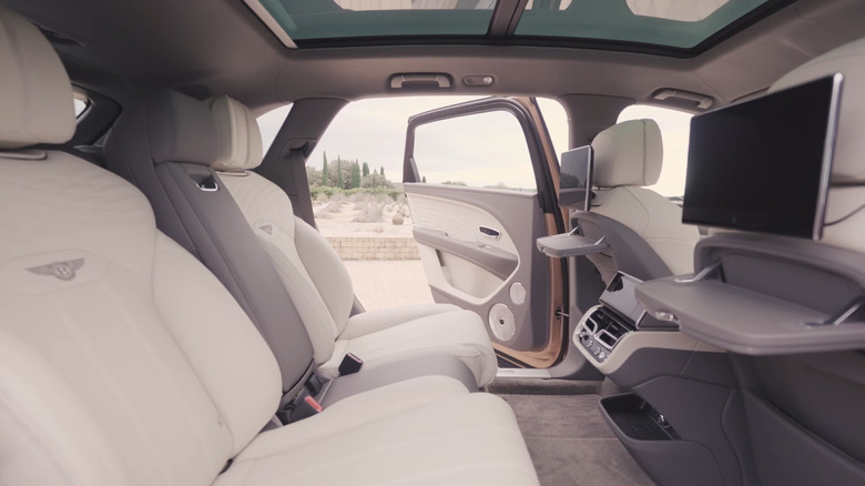 The second row of the 2026 Bentley Bentayga, its left passenger door open and its large rear screens on display