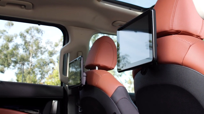 The interior of the 2026 Kia Carnival from the back seat, showcasing the dual rear infotainment screens