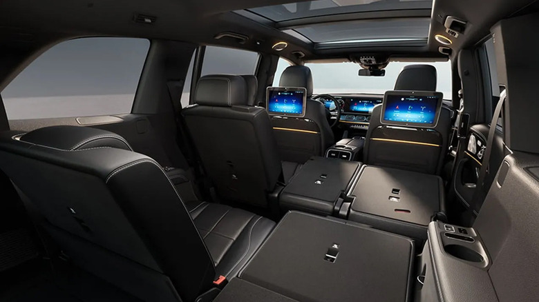 The interior of the 2026 Mercedes-Benz GLS, showcasing folded second- and third-row seats and dual rear screens