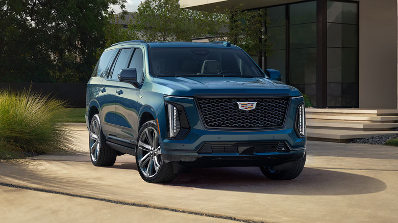 A dark blue 2026 Cadillac Escalade parked in front of a house