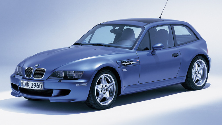 A blue BMW E36 Z3 Coupe in a studio, blue and white background.