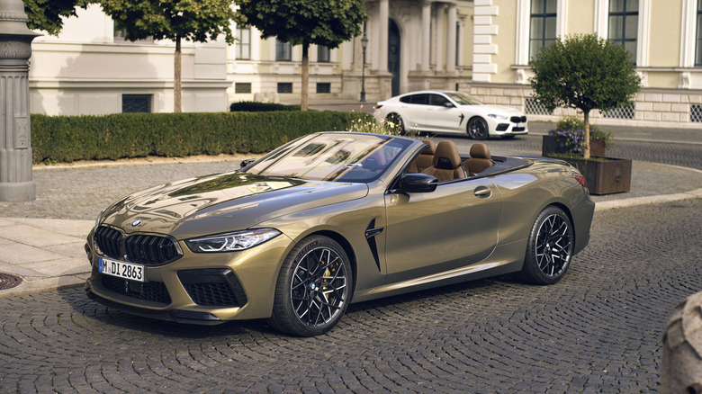 A green BMW M8 Competition Convertible parked, white BMW M8 Competition in the background.