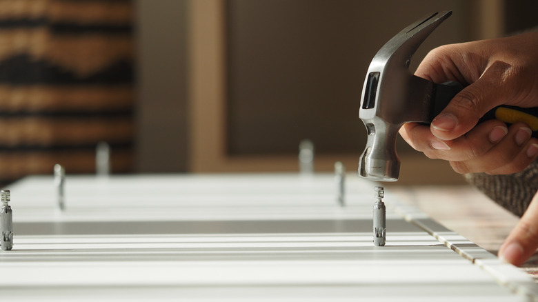 A person using a hammer on a table