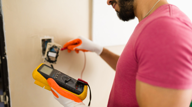 A person checking the voltage of their wall sockets