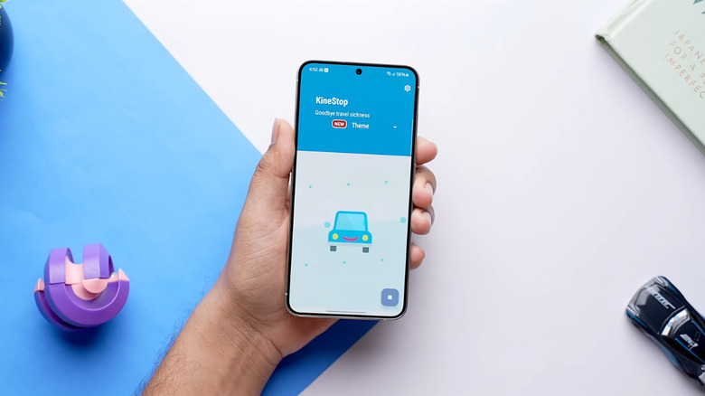 A person holding a phone with the KineStop app running