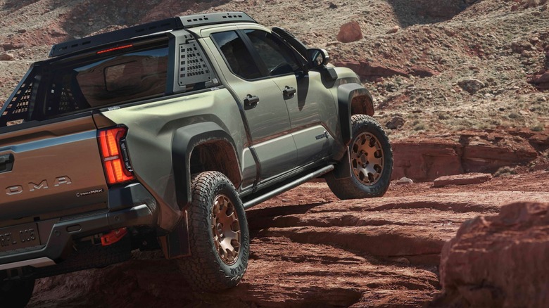 a Toyota Tacoma climbing a rock