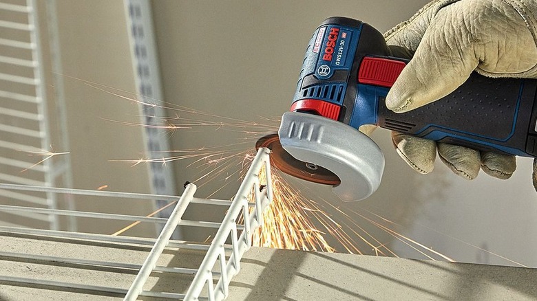 Mini angle grinder being used on the side of metal wires