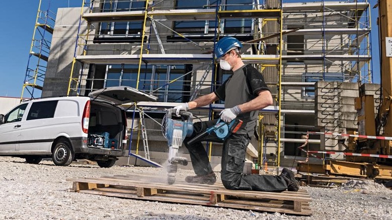 Construction work cleans up dust off a tool using the 18V blower