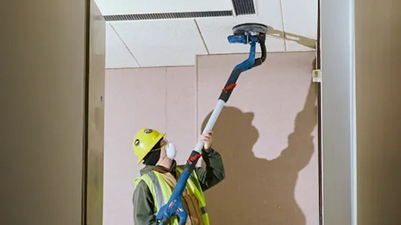 Bosch 9-inch drywall sander being used on ceiling drywall