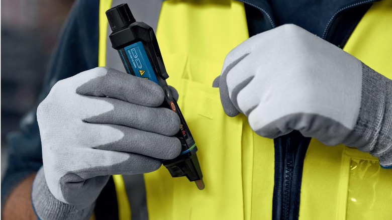 Bosch voltage tester about to be clipped to the front of a person's vest