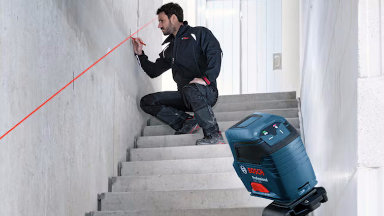 Work drawing measurements on a wall using the self-leveling cross-line laser