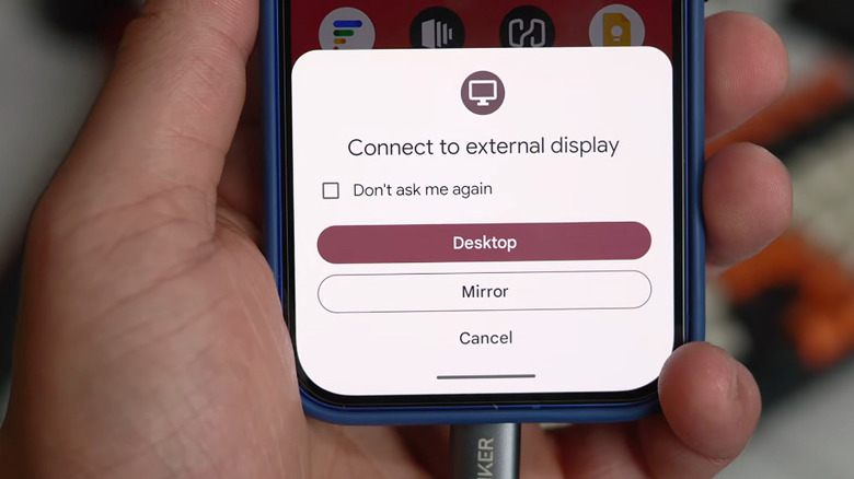 Desktop mode appearing on a Pixel phone held in hand.