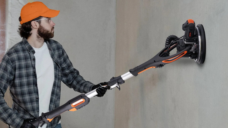 Man using Vevor 900W Drywall Sander for home renovation