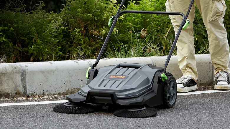 Man pushing the Vevor Walk-Behind Hand Push Floor Sweeper