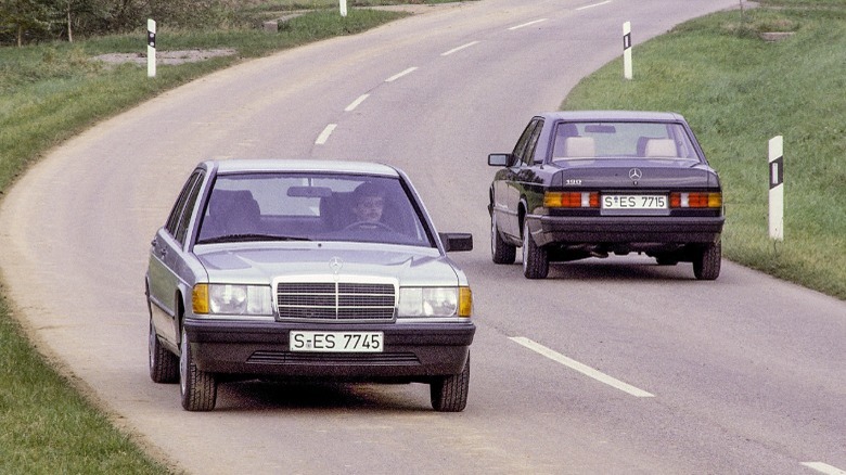 Two Mercedes-Benz 190 sedans are parting ways on a public road
