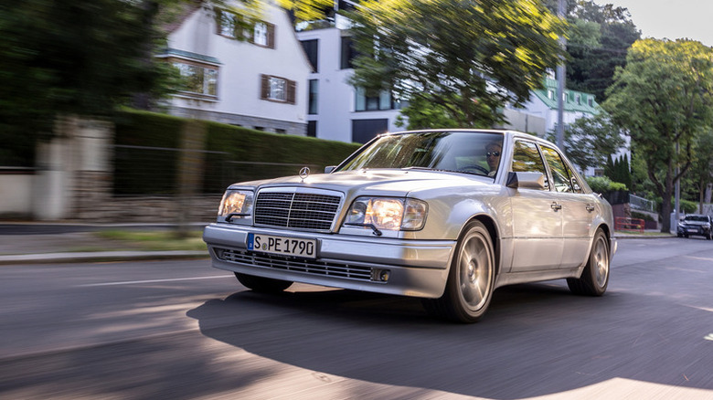 Silver metallic Mercedes-Benz E-Class W124 driving on street