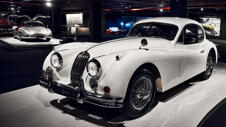 Front 3/4 view of Jaguar XK140 coupe in museum setting