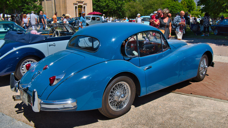 Rear 3/4 view of Jaguar XK140 coupe in outdoor auto show setting