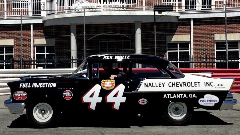 1957 Chevrolet 150 "Black Widow" sedan parked in front of a brick building