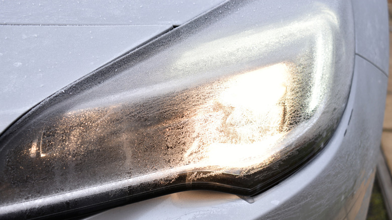 A close-up view of a car's headlight frozen over