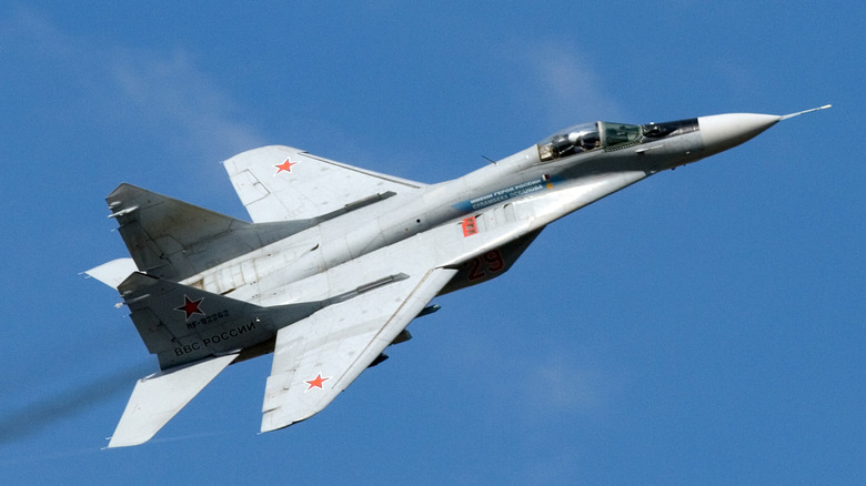A MiG-29 fighter jet in flight with a blue sky background