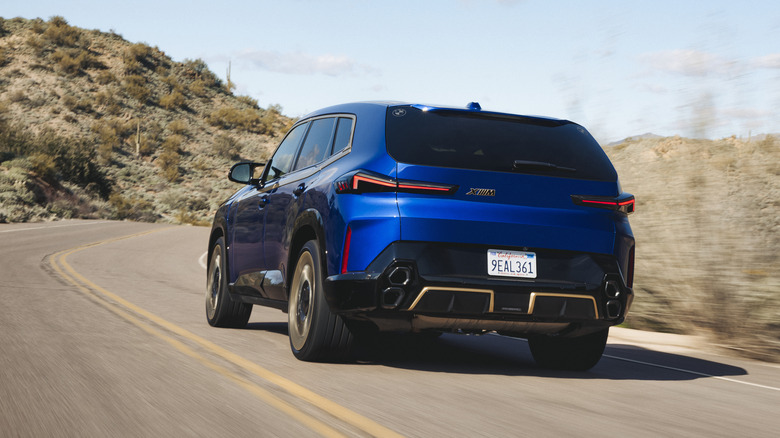 2023 BMW XM in blue driving on mountain roads