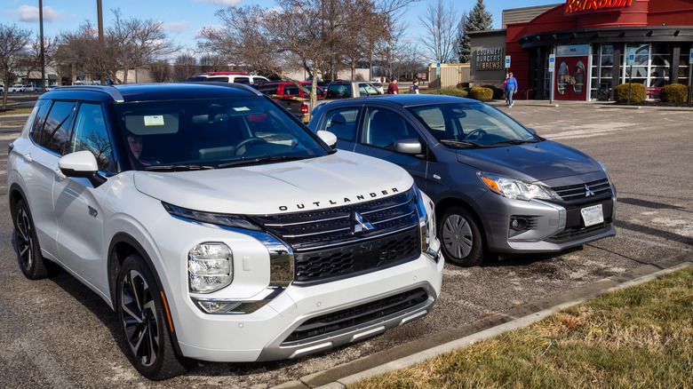 2023 Mitsubishi Outlander PHEV parked next to Mitsubishi Mirage