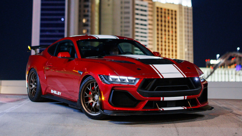 Front quarter shot of a red Shelby Mustang Super Snake against a city backdrop