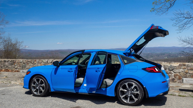 2026 Honda Civic Hatchback Hybrid driver's side view with left front and rear doors and hatch open
