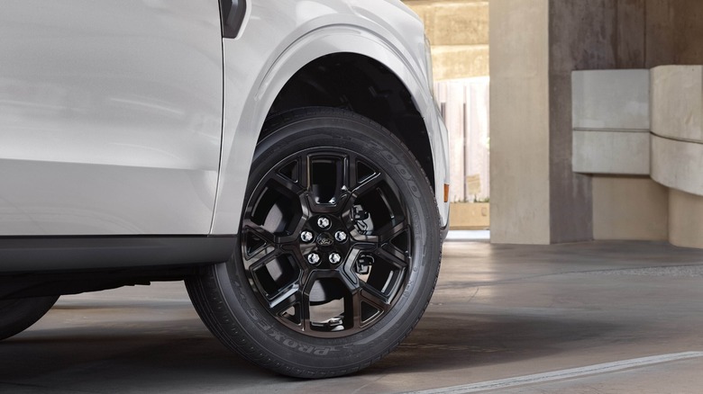 Close-up of front right wheel of a white Ford Maverick