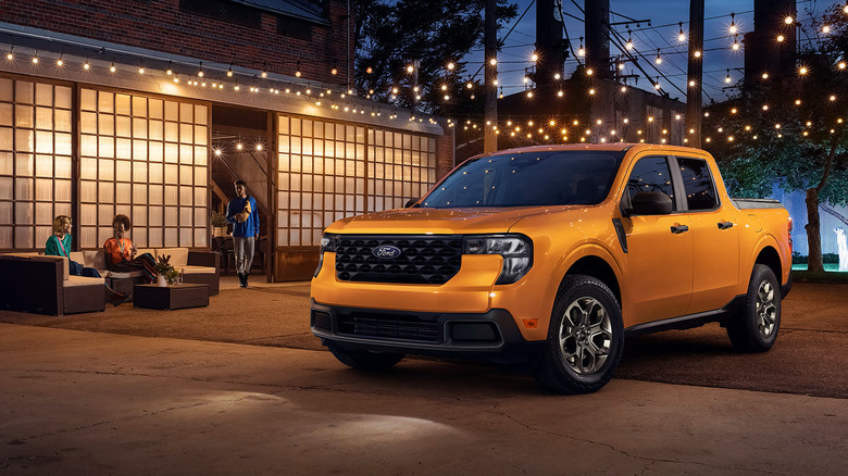 Orange 2026 Ford Maverick parked in front of a building at night