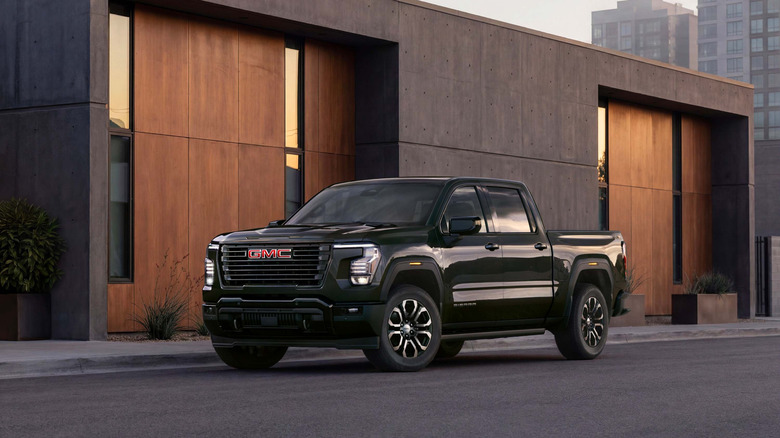 Black 2027 GMC Sierra parked in front of a minimalist building