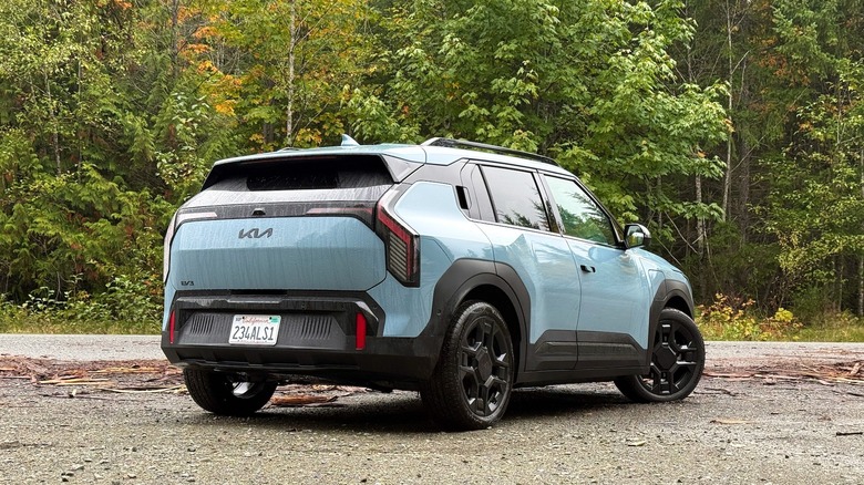 2027 Kia EV3 rear 3/4 parked in a Canadian forest with large trees