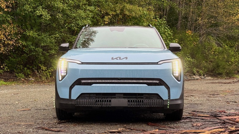 2027 Kia EV3 front fascia parked in the woods near bark and trees