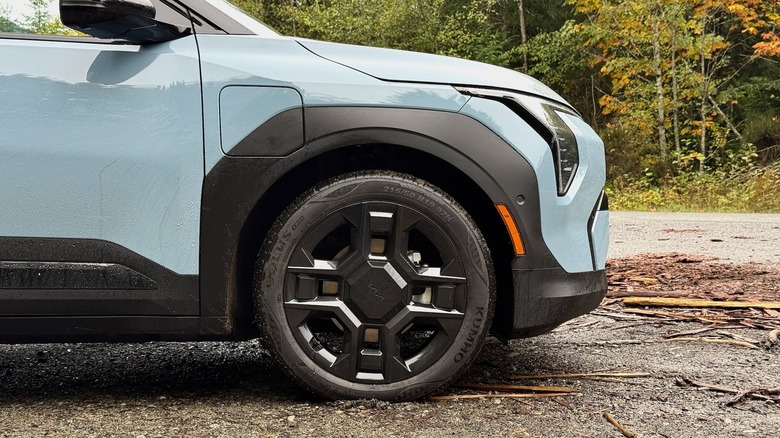 2027 Kia EV3 front wheel with trees in the background